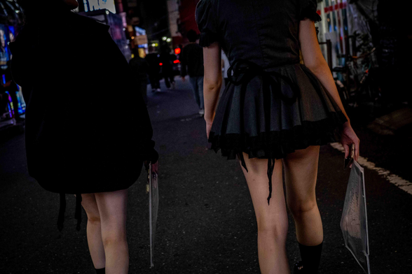 Dues noies amb vestits curts i maniga curta, de color negre, caminant pels carrers de Kabukicho.