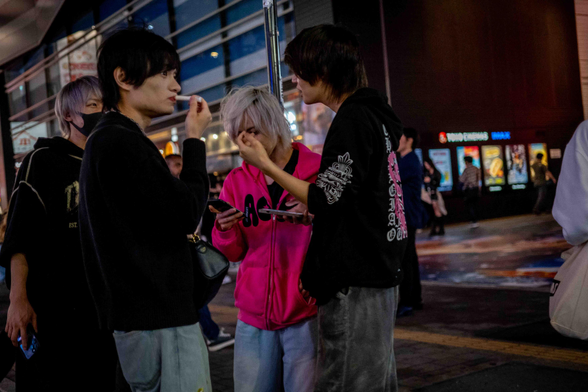 Grup de 'touts' (persones que inciten la gent del carrer a anar a algun establiment determinat) als carrers de Kabukicho mentre fan una cigarreta.