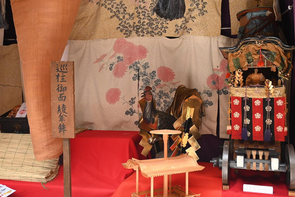 綾傘鉾の鉾頭として使用されている雄鶏像と、曳鉾時代の鉾を模した綾傘鉾模型。菊水鉾のような唐破風造りの屋根に現在の傘鉾の傘が乗っている。/ 2026.07.14 綾傘鉾・大原神社から