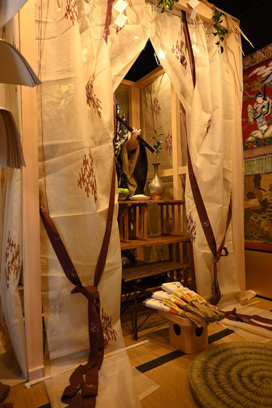幕に覆われたご神体の伯牙像。正面だけが少し開けられていて、姿が見られるようになっている。斜めからの撮影で、伯牙像の左手のみが見えている。/ 2026.07.14 綾小路通・伯牙山保存会所から