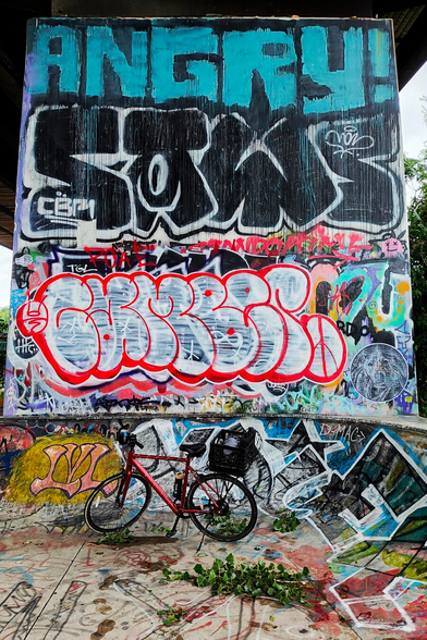 Bike in front of graffitied skate park wall