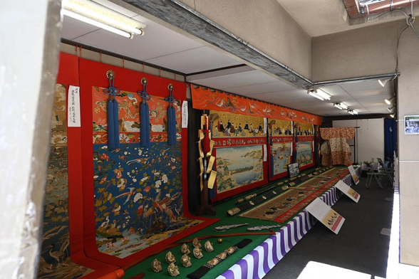 1枚目の懸装品展示を会所の奥から入口側に向かって撮影。入口側に小袖が展示されているのが見える。/ 2026.07.14 錦小路通・占出山保存会所から