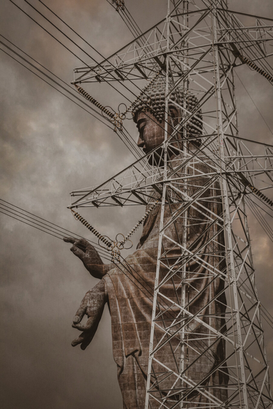 A side profile of the colossal Ushiku Daibutsu statue in Japan, framed behind a massive steel electricity pylon against a moody, overcast sky. The intricate white lattice of the pylon segments the dark stone of the Buddha, while power lines stretch like energy veins directly towards its chest and raised hands. It appears as if the serene deity is silently absorbing cosmic power from the modern grid.