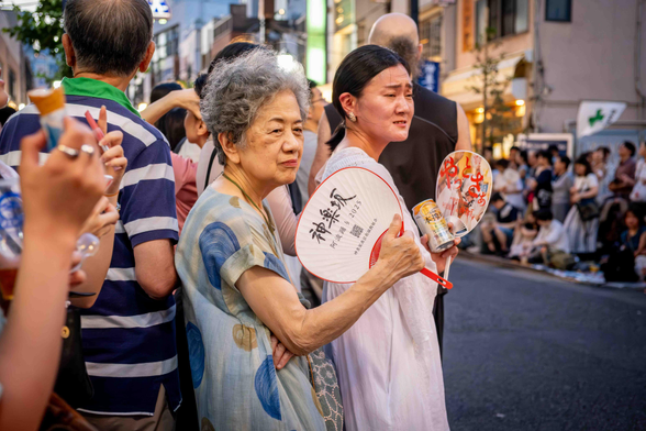Dona gran amb ventall esperant l'arribada dels ballarins del Awa Dori a Kagurazaka