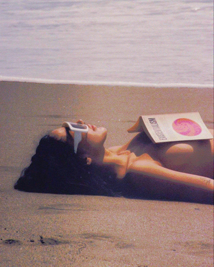 allongée sur la plage, une jeune femme confie la protection de son capital solaire à la philosophie existentialiste