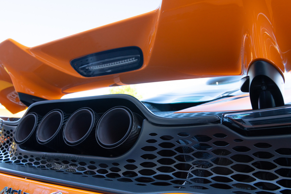Wing and exhaust detail of an orange exotic car
