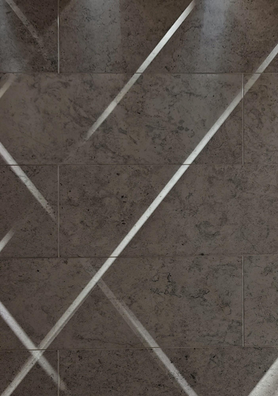 A photo of a textured stone or wall with rectangular tiles. Thin diagonal stripes of light are criss-crossing across the surface.