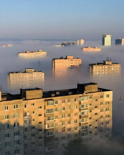 dans le petit matin, les logements de la ville émergent de la brume dans le soleil levant