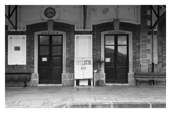 Zwei Türen an einem alten Bahnhofsgebäude, eine mit Aufschrift "Uscita", eine mit "Telegrafo".
