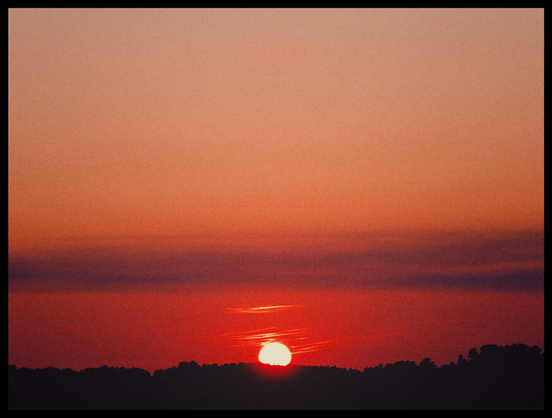 Die untergehende Sonne färbt den Himmel tief rot.