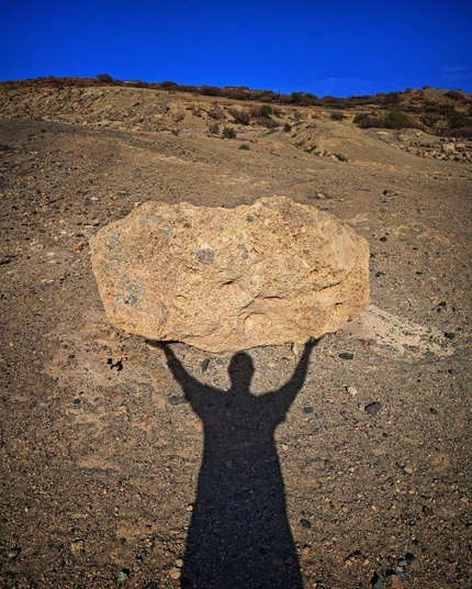 une ombre sisyphéenne soulevant un rocher dans une illusion de victoire sur le climat