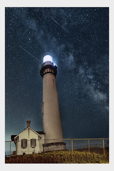 A lighthouse with a bright light at the top stands against a starry night sky, featuring the Milky Way and several shooting stars. A small house is adjacent to the lighthouse, enclosed by a fence.