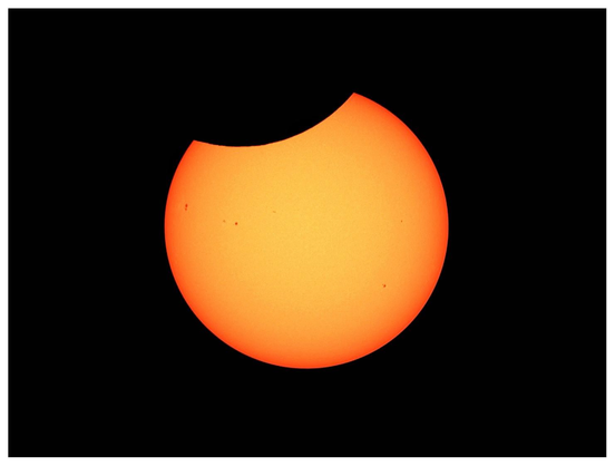 Image of the sun, yellow with visible sunspots, slightly obscured by the curve of the silhouetted moon grazing its upper section. Basically the sun looks like a cookie with a small bite taken out of its top. Imaged with a Dwarf 3 smart telescope in Brooklyn, NY, August 12, 2026 at 1:54pm, 50 stacked photos.
