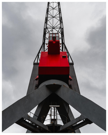 Ein quasi natürliches colorkey Foto, das einen Hafenkran von unten zeigt. Nur die Fahrerkabine ist rot, der Rest ist schwarz weiß. (Farben minimalst bearbeitet).