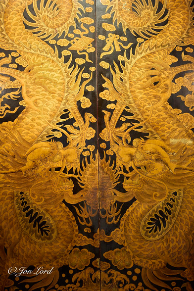 This is a simple colour photo of the two closed doors at the entrance to an old temple decorated with two large golden serpentine, dragon-like, mythical sea creatures facing each other. Thian Hock Keng Temple, Singapore (2012).

The entire photo is filled with the two, tall and rectangular, closed doors. The hinges are out of view along the left and right edges of the photo with the gap between the two doors being in the centre of the image. Each door has an identical mythical sea creature, possibly made from gold leaf, either way, of a metallic gold appearance. At the top of the doors the creature's tail curls around in a loop with the snake like body curving down the length of the door and getting a little thicker (fatter) towards the centre. Three-quarters of the way up there is a paw with five claws. At the bottom of the door the body curves around and upwards with the dragon like head stopping just below the centre of the photo. The jaws are wide open revealing long rows of sharp teeth and a long tongue protruding from the mouth. On top of the head at the back are two antler like extensions with two long and curling antennas just forward of the bulging eyes.  The space between the creatures is filled with small golden clouds and some breaking waves at the base. 

The doors are at the entrance to the Thian Hock Keng Temple, translated as the "Palace of Heavenly Happiness" the oldest and most important temple of the Hokkien (Hoklo) people in Singapore. While the temple is built for the worship of Mazu, a Chinese sea goddess, there are also shrines for Taoism, Confucianism & Buddhism.

I cannot imagine any other Western or Eastern religions being that tolerant. 