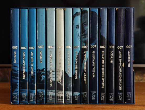 A photo showing a book box with a collection of blue and black books by Ian Fleming. The number 007 is prominently displayed, the titles are in Dutch.