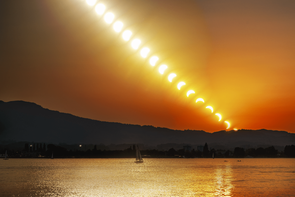 Diagonale Bildfolge der Sonne in verschiedenen Verfinsterungsstadien am Abendhimmel über einem See, von kaum verdeckt bis fast vollständig als Sichel, mit Bergsilhouette, Segelbooten und Wasserreflexion im Vordergrund.