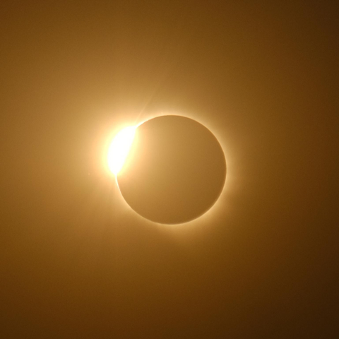 Éclipse de soleil. Le soleil est presque totalement masqué. On aperçoit la couronne solaire et encore un éclat en haut à gauche
